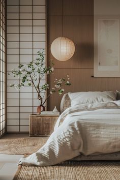 a bed sitting in a bedroom next to a plant on top of a wooden table