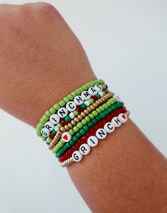 Grinch Stacking Seed Bead Bracelet,  Stink Stank Stunk, Grinch Gift, Christmas Jewelry, Holiday Bracelets, Gold, Green and Red Christmas How to find your bracelet size: Wrap a flexible tape measure, string, or ribbon around your wrist. Find your measurement and then add 1/2 an inch. This will ensure a comfortable fit for your stackable bracelets.   Bracelet care: -remove when sleeping -avoid over stretching -allow lotions to dry before wearing -remove before entering water -Made with clear stretchy elastic cord. Looking for different text on your bracelet?  Feel free to contact me with any personalization. Christmas Stretch Bracelets Ideas, Grinch Friendship Bracelet, Grinch Beaded Bracelet, Grinch Bracelet Ideas, Christmas Seed Bead Bracelets, Christmas Bead Bracelets, Christmas Friendship Bracelets, Grinch Jewelry, Grinch Bracelet