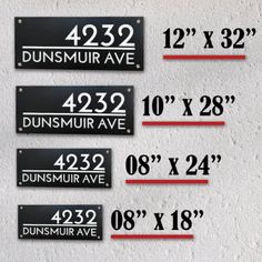 three black and white street signs on a wall