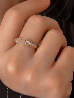 a woman's hand with a gold ring on top of her finger and diamond band