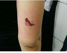 a woman's arm with a red shoe tattoo on the left side of her arm