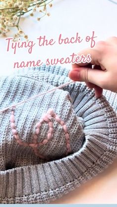 someone is knitting a sweater with the words tying the back of your name sweaters