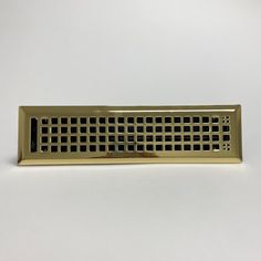 a gold colored metal grate sitting on top of a white table