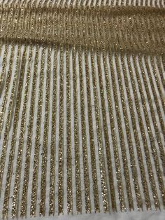 gold sequins on white fabric with snow in the foreground and behind it