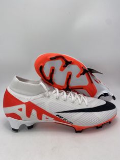 a pair of white and red soccer shoes on a white background with black accents,