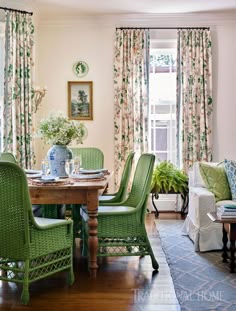 a dining room with green chairs and curtains