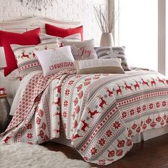 a bed covered in red and white sheets with deers on it, next to a window