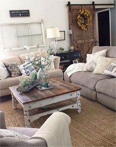 a living room with couches, tables and flowers in vases on the coffee table