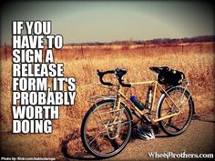 a bike parked on the side of a road next to a tall grass covered field