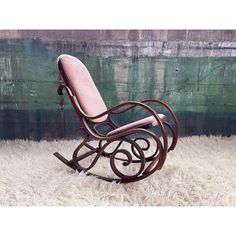 a wooden rocking chair sitting on top of a white rug