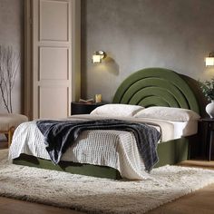 a bedroom with a green headboard and white bedding, rugs on the floor