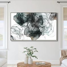 an abstract painting hangs on the wall above a coffee table in a white living room