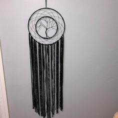 a black and white dream catcher hanging on the wall