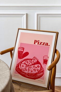 a framed pizza advertisement sitting on top of a wooden chair next to a plate of food