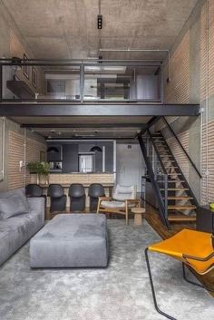 a living room filled with furniture and a stair case in the middle of it's walls