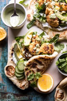 two pita breads with salad and dipping sauce