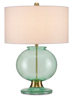 a green glass table lamp with a white shade on the base and a gold metal base