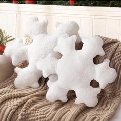 three snowflakes sitting on top of a blanket next to a potted plant