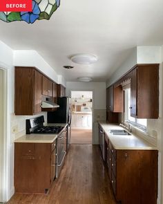 an empty kitchen with wood cabinets and white counter tops is seen in this image from the hallway