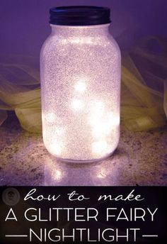 a glass jar with lights in it sitting on a table next to a purple background