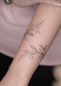 a woman's arm with a flower tattoo on the left side of her arm