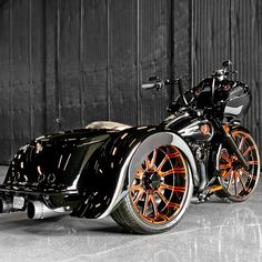 a black and orange motorcycle parked in front of a building