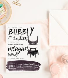 the wedding stationery is laid out on top of some pink and white paper, including an envelope