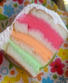 a slice of rainbow cake sitting on top of a colorful plate