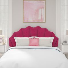 a bed with pink headboard and pillows in a white walled room next to two nightstands