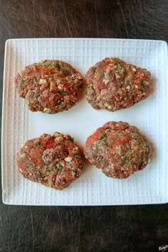 four meat patties on a white plate