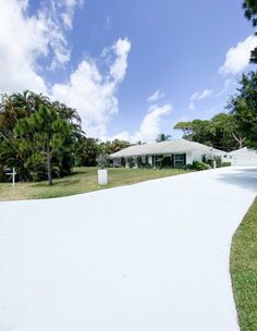 a white house sitting on top of a lush green field