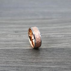 a wedding band with two tone gold and silver inlayed to the side on a wooden surface