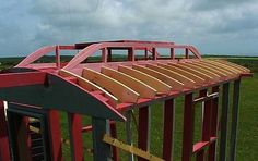 a wooden structure in the middle of a field