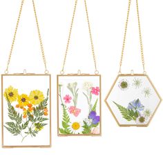 three paintings hanging from chains with flowers on them