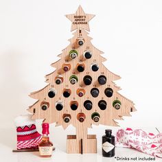 a wooden christmas tree with wine bottles in it and other holiday decorations around the tree