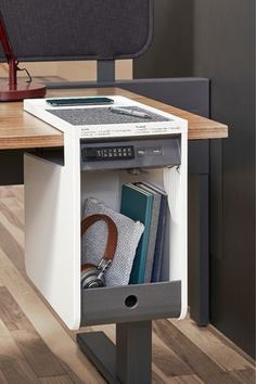 an open drawer in the middle of a desk with books and other items on it