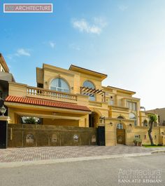 a large yellow house with an iron gate