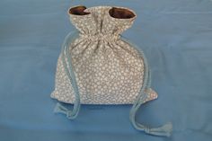 a small white bag with glasses on it sitting on a blue tablecloth covered surface