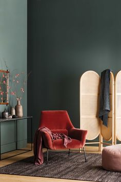 a living room with two chairs and a rug in front of the couch, next to a cabinet