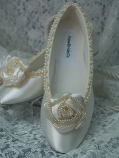 READY TO SHIP SHOES USA SIZE: 6, AS SHOWN IN PICTURE. READY TO SHIP SHOES USA SIZE: 8, AS SHOWN IN PICTURE. *If you need a different color or size please see below. COLOR: IVORY Description: Fancy Flower 1.5'' X 1.5'' pearl edging, unique pearls edging trim on shoe. Gorgeous Ivory Satin Flower Rosette with Pearls along the edges. So exquisite and unique. Perfect for after a long day of heels. These flats are satin, with man-made insoles, and sueded leather outer soles. (Please Note: These are NO Elegant Slip-on Ballet Flats For Wedding, Elegant Cream Ballet Flats With Round Toe, Ivory High Heels, Ivory Flats, Lace Garter Set, Pearl Bracelet Wedding, Great Gatsby Fashion, Ivory Shoes, Ballet Style