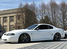 a white sports car parked in front of a building