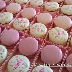 pink and white macaroons are in a box with writing on the top one