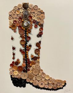 a cowboy boot made out of buttons and other things on the wall with a clock