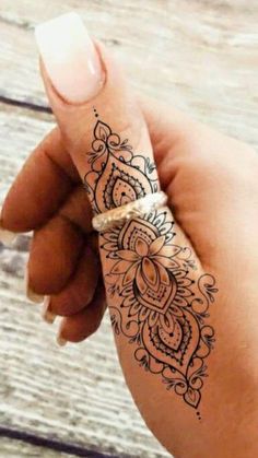 a woman's hand with a henna tattoo on her wrist and the arm