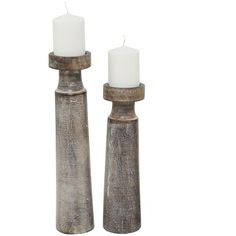 two tall wooden candlesticks with white candles