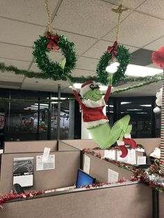 an office cubicle decorated for christmas with decorations and wreaths hanging from the ceiling