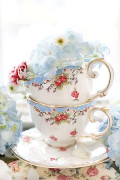 two cups and saucers with flowers on them