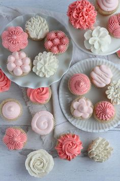 cupcakes and muffins are arranged on white plates with pink frosting