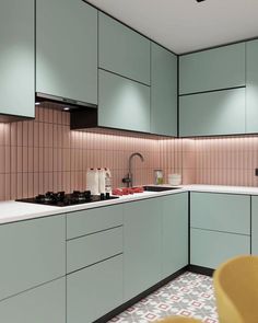 a kitchen with pastel green cabinets and white counter tops is seen in this image