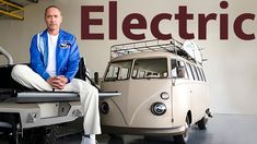 a man sitting on top of a car next to an old vw bus